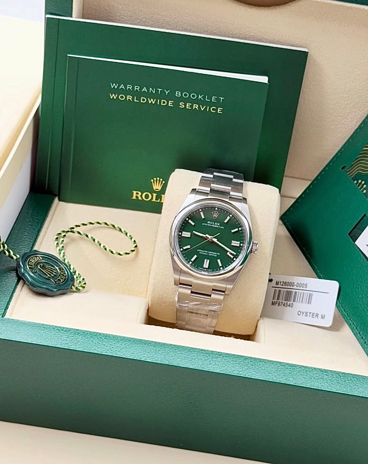Rolex Oyster Perpetual 36 reference 126000 with green dial on Oystersteel Oyster bracelet, front view with booklets and hang tag