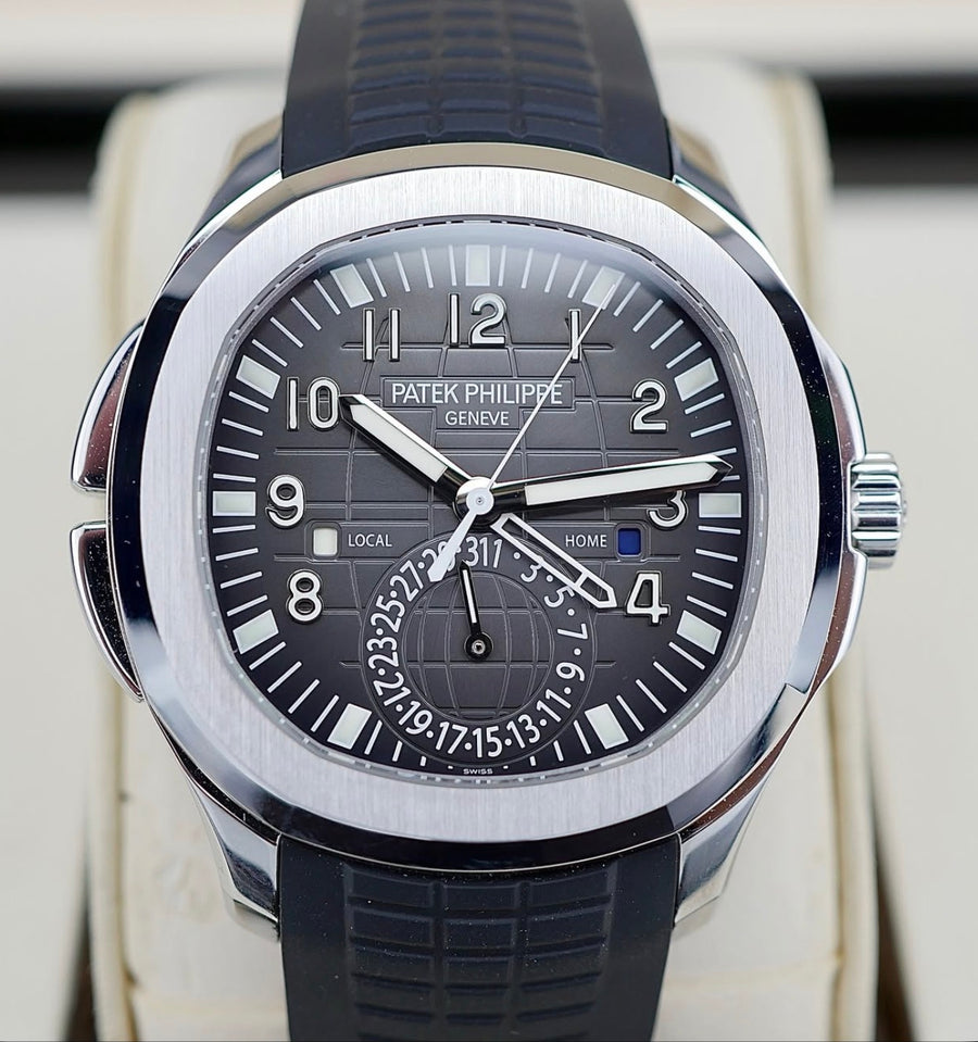 Patek Philippe Aquanaut Travel Time 5164A-001 in steel with black embossed dial and black composite strap, tight straight-on dial view