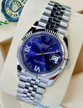 Angled view of the Rolex Datejust 36 126234 aubergine dial and Jubilee bracelet beside a green Rolex hangtag.