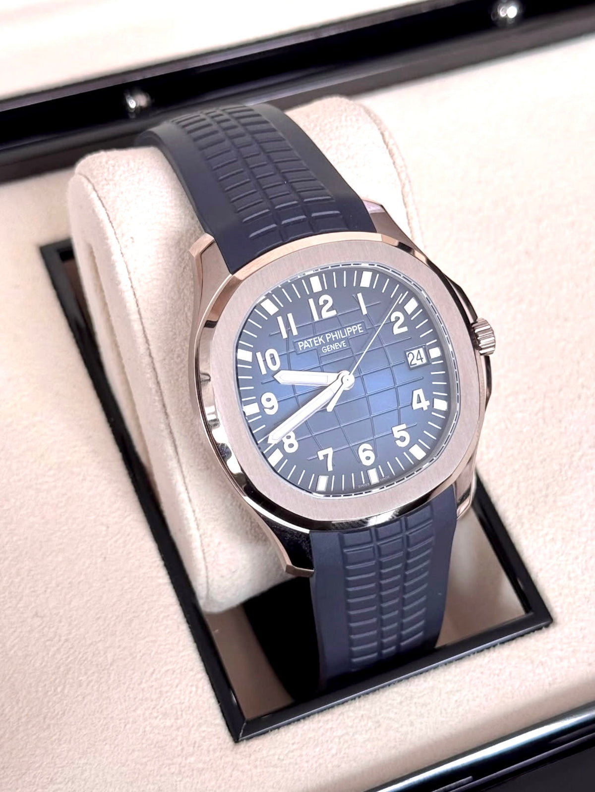 Patek Philippe Aquanaut 5168G-001 in white gold with blue embossed dial and blue composite strap, wide three-quarter front view in the box