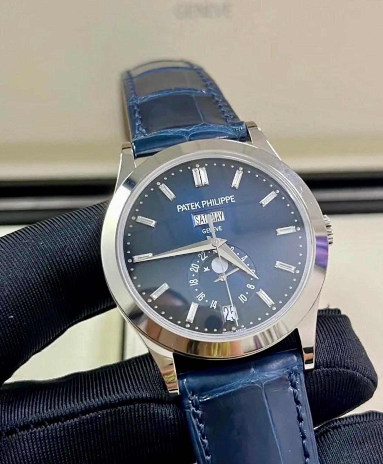 Patek Philippe Annual Calendar 5396G-017 in white gold with blue dial and blue alligator strap, three-quarter front view held in a gloved hand