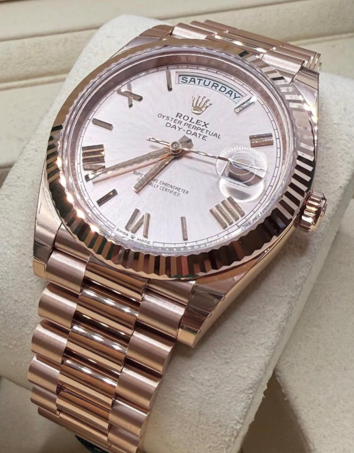 Rolex Day-Date 40 228235 crown-side angled close-up on cushion with Sundust Roman dial and fluted bezel