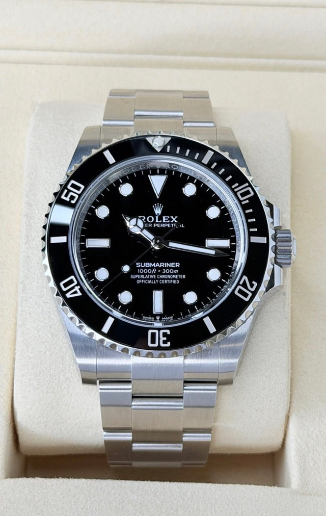 Rolex Submariner No Date 124060 black dial and black bezel, straight-on front view on cream box