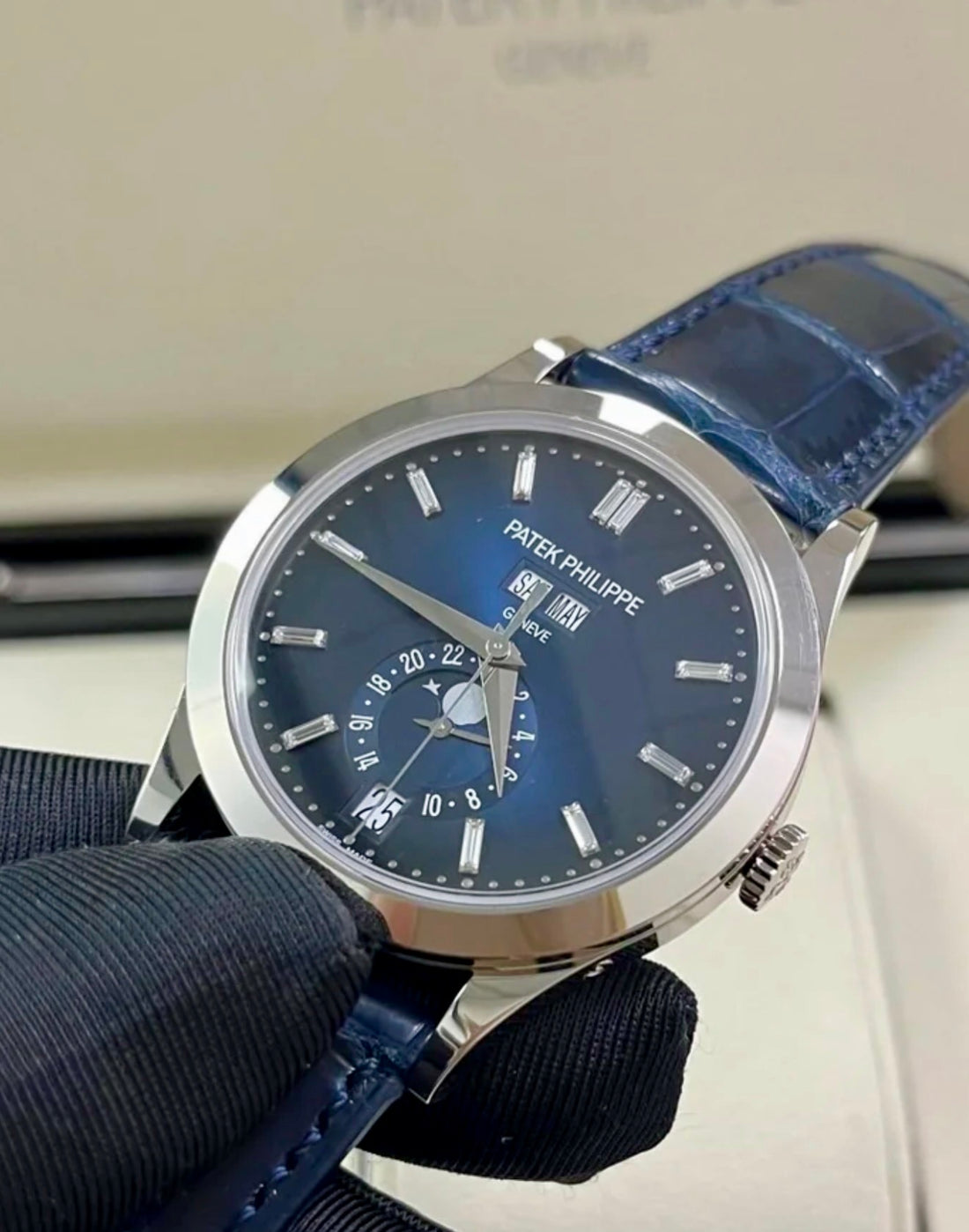 Patek Philippe Annual Calendar 5396G-017 in white gold with blue dial and blue alligator strap, angled front view held in a gloved hand