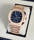 Patek Philippe Nautilus Travel Time Chronograph 5990/1R-001 in rose gold with blue dial and bracelet, three-quarter front view on a cushion