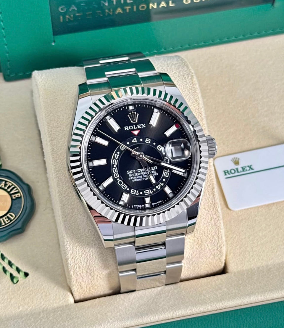 Rolex Sky-Dweller 336934 angled front view with black dial, fluted white-gold bezel and Oyster bracelet in presentation box