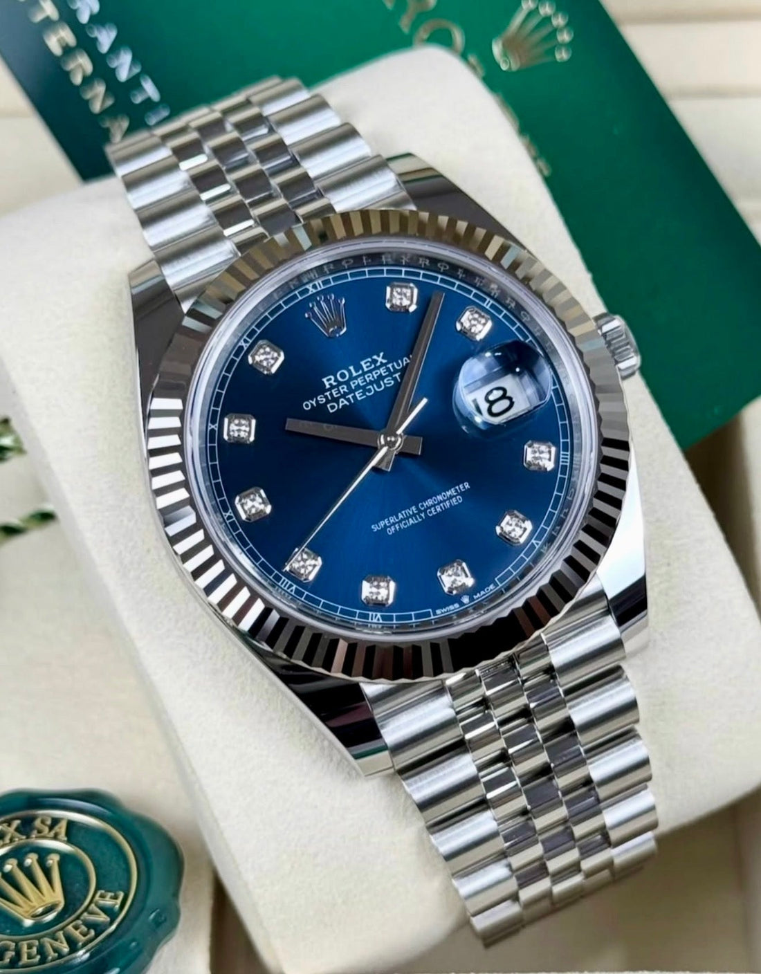 Rolex Datejust 41 126334 diagonal close-up with blue diamond-set dial, fluted bezel and Jubilee bracelet beside Rolex hangtags